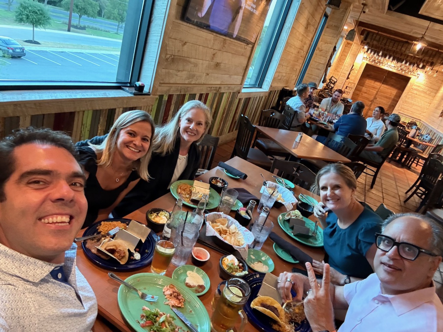 A table of six neighbors with tacos and drinks at the first Dinner Club.