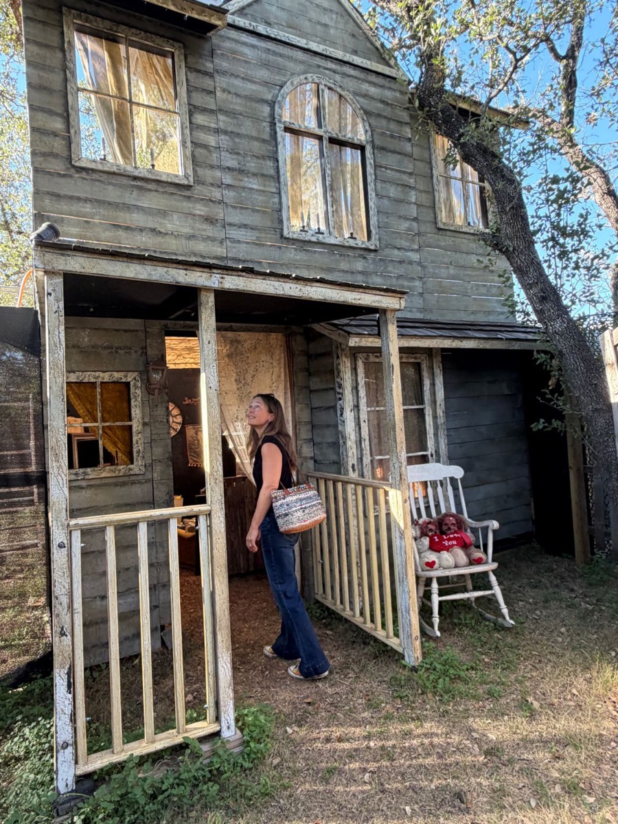 April Garner looking up at the weathered front porch of a two-story house inside the haunted compound