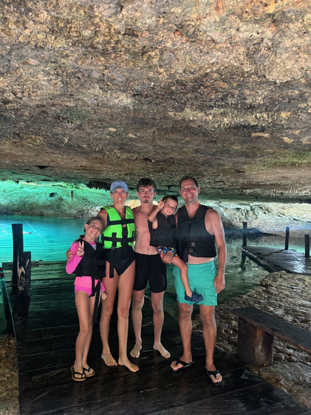 The Erickson family of five in life jackets inside a cenote
