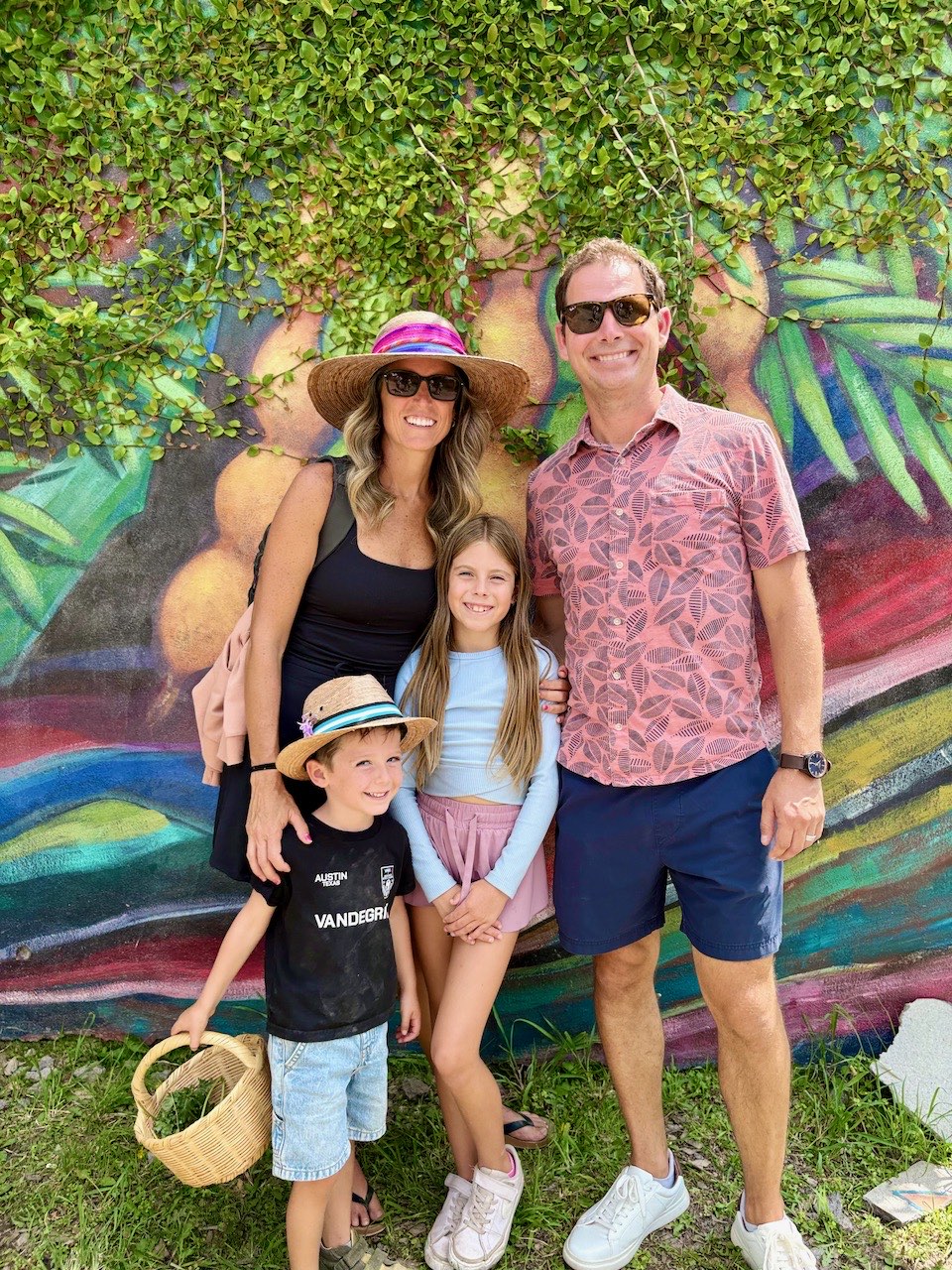 Salissa and Cris Erickson with their two youngest children in front of a colorful mural