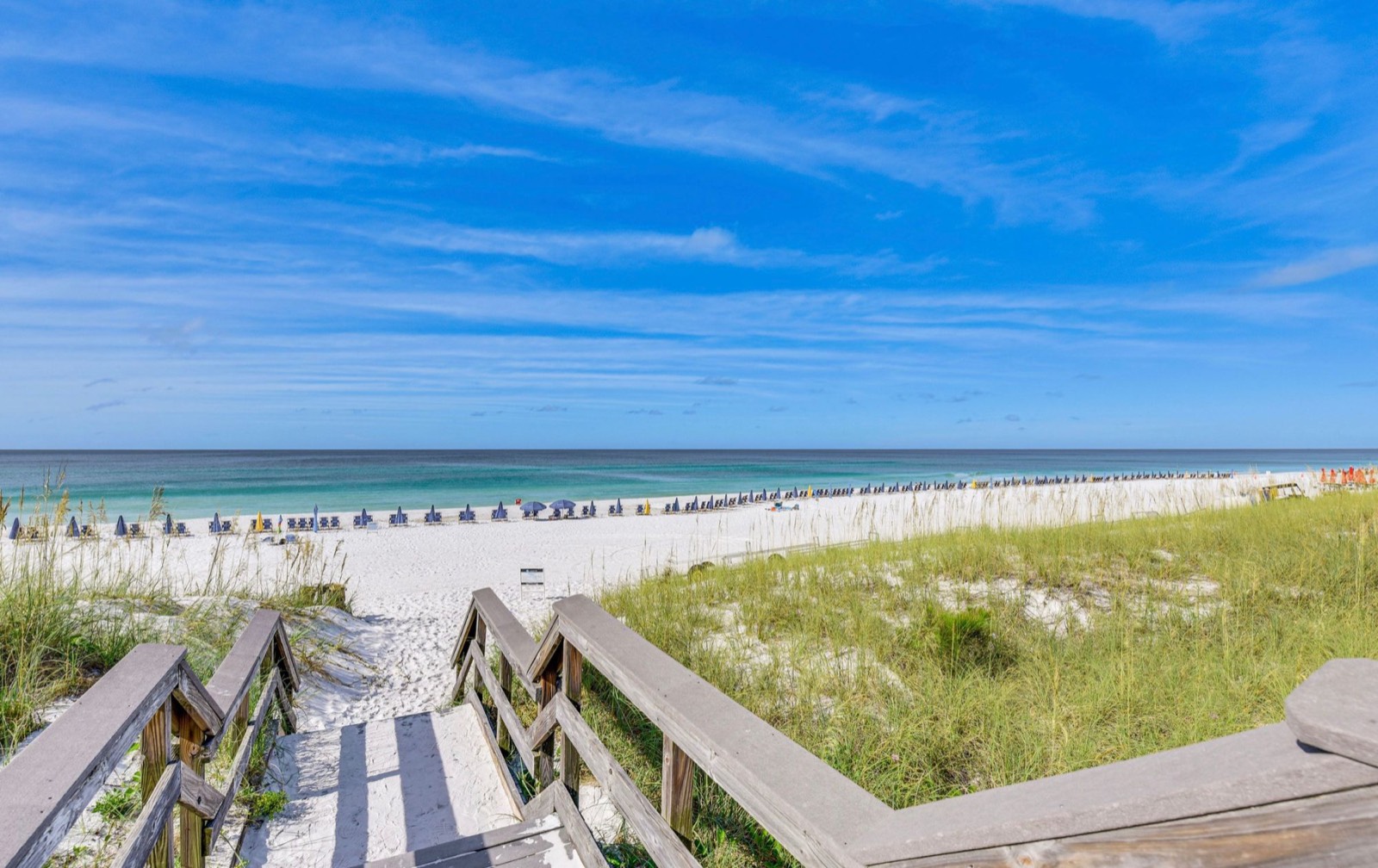 Boardwalk through the dunes to Miramar Beach's white sand and emerald water