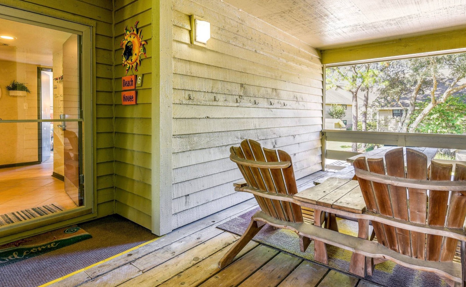 Entry porch with Adirondack chairs and Beach House sign