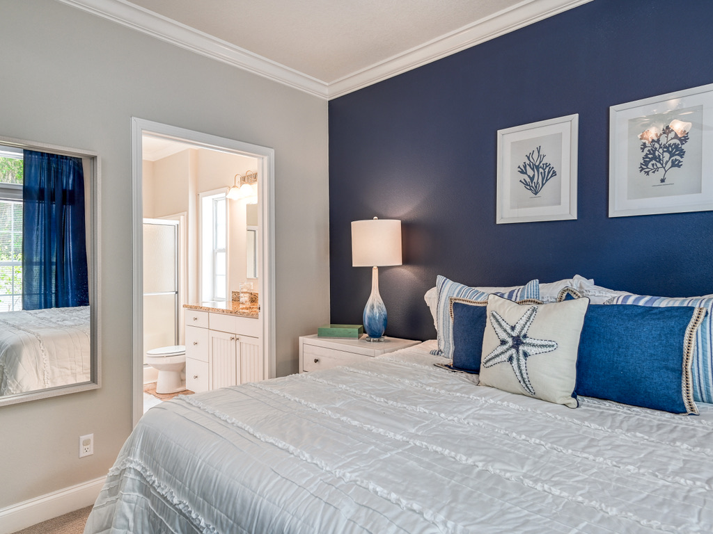 Primary bedroom with a navy accent wall and en suite bath